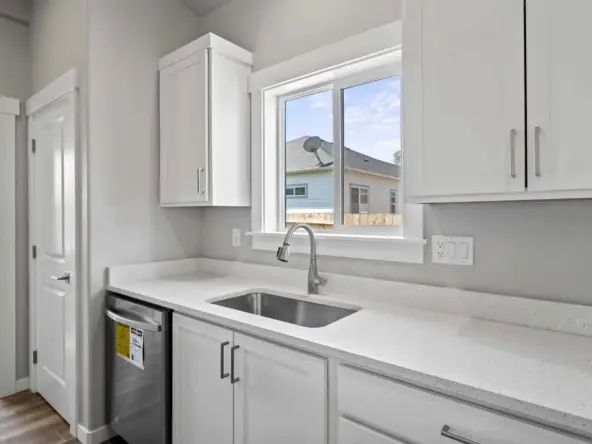 A Bright White Kitchen with Crisp Cabinets, Gleaming Countertops, and a Stunning Sink