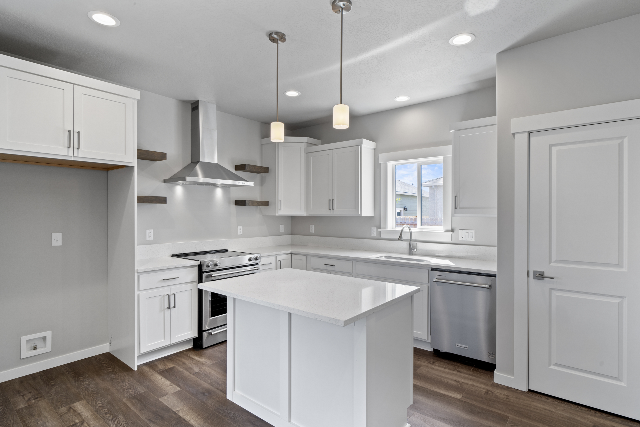 An inviting kitchen with sleek white countertops and modern stainless steel appliances.